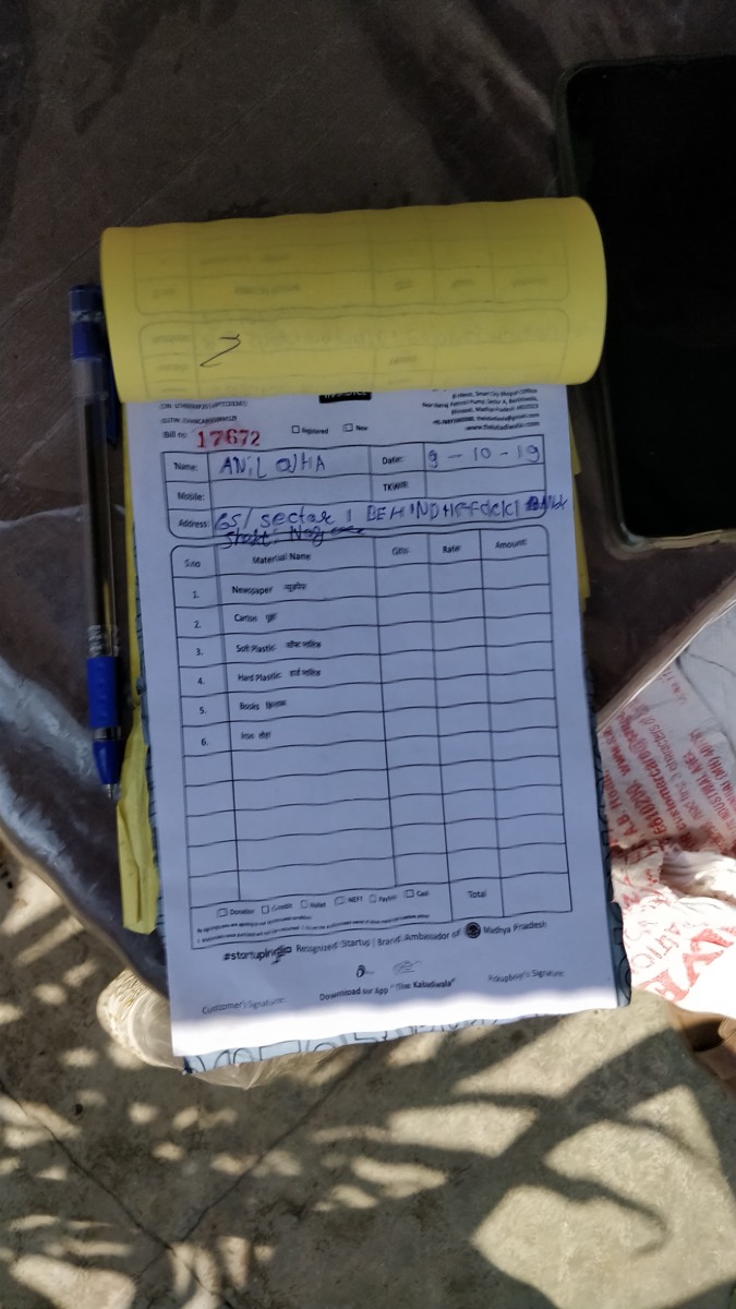 A handwritten scrap-rate receipt on a paper pad, with a pen resting beside it